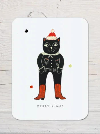 Weihnachtskarte mit einer Katze, die wie ein Cowboy aussieht, sie liegt auf einem Holztisch